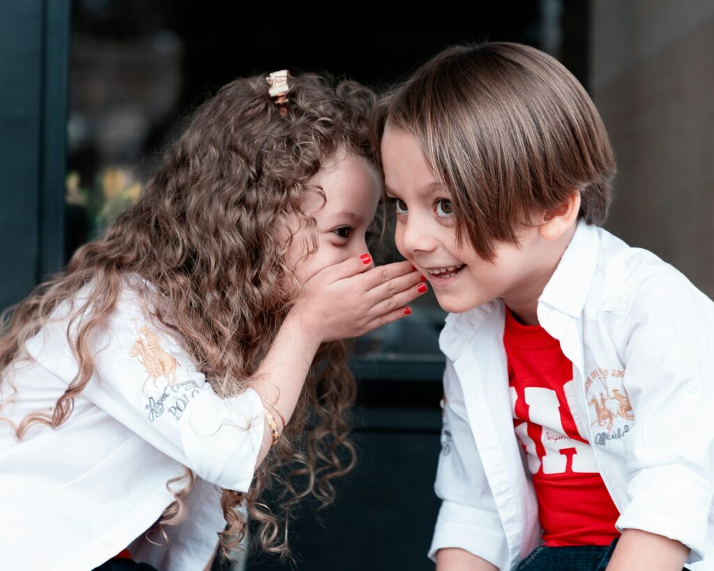 A girl whispering to a boy